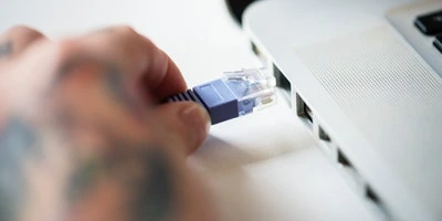 Connexion d'un câble réseau Ethernet RJ45 sur un routeur pour intégrer la IoT Box Odoo au réseau local de l'entreprise